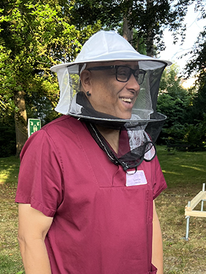 Foto von Praxisanleiter Karsten Lies mit Bienenschutzkaube